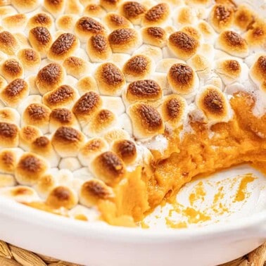 Sweet potato casserole in a baking dish with a spoonful removed.