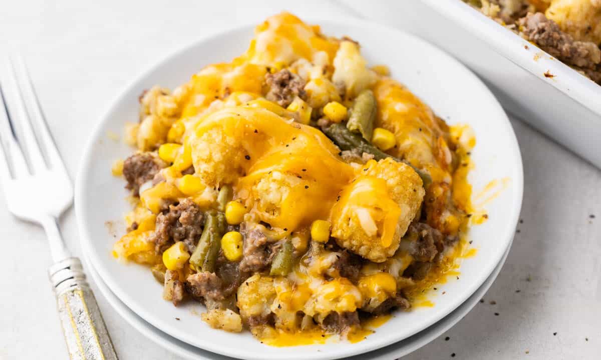 A white dinner plate with a serving of tater tot casserole.