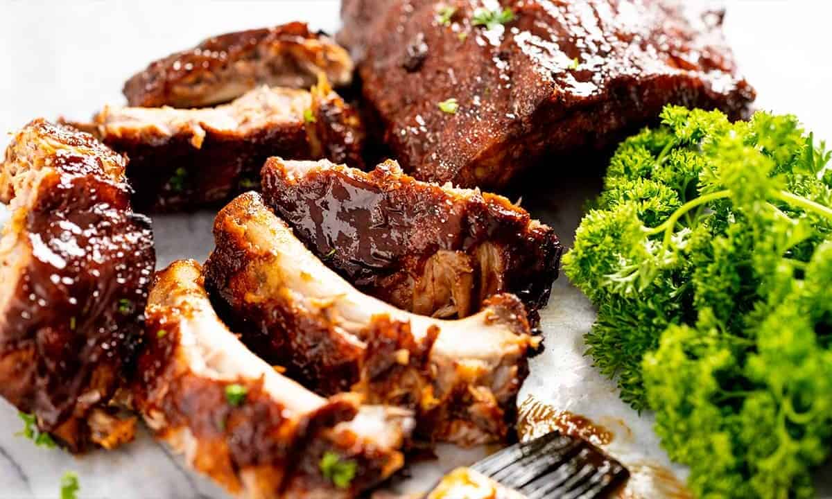 Close up of pulled ribs off the rack of slow Cooker Ribs on a marble slab.