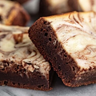 Angled view of Cheesecake Brownies cut into squares.